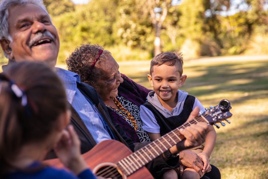 Aboriginal man playing music with his family